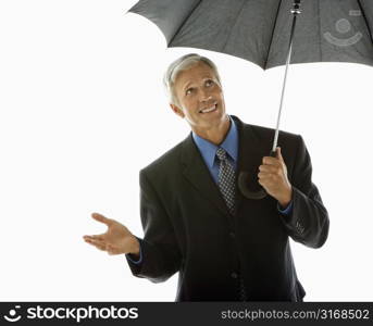 Caucasian middle aged businessman holding umbrella and gesturing.