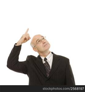 Caucasian middle-aged businessman looking and pointing up standing against white background.