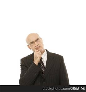 Caucasian middle-aged businessman looking thoughtful standing against white background.