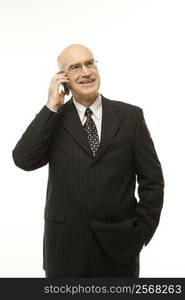 Caucasian middle-aged businessman talking on cellphone against white background.