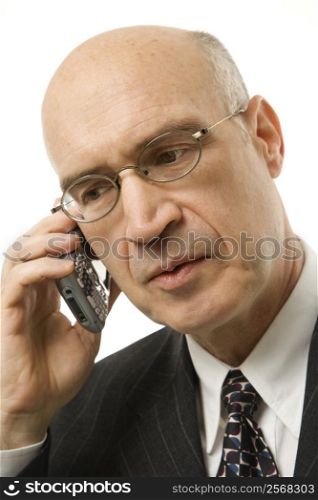 Caucasian middle-aged businessman talking on cellphone against white background.