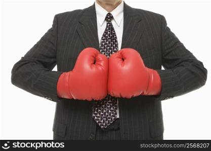 Caucasian middle-aged businessman wearing boxing gloves