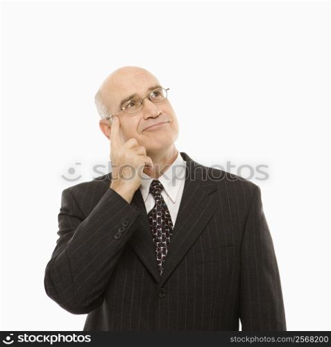Caucasian middle-aged businessman with hand to head looking thoughtful standing against white background.