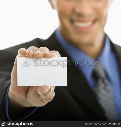 Caucasian middle aged man holding business card toward viewer.