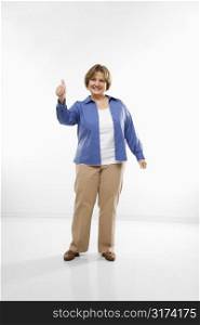 Caucasian middle aged woman giving thumbs up and smiling at viewer.