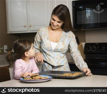 Caucasian mother and daughter with cookies.