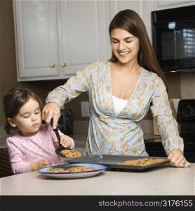 Caucasian mother and daughter with cookies.
