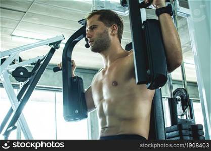 Caucasian muscular man is doing exercise in gym. Sport Concept.