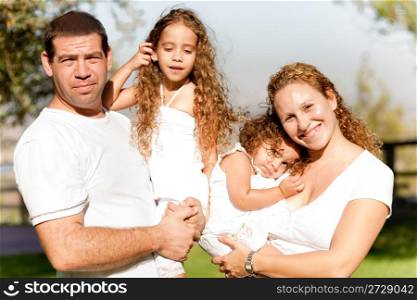 Caucasian Parents carrying their kids in the park