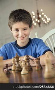 Caucasian pre-teen boy playing chess.