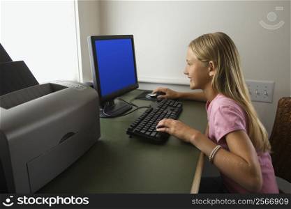 Caucasian pre-teen girl using computer.