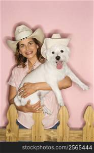 Caucasian prime adult female and white terrier dog wearing cowboy hats.