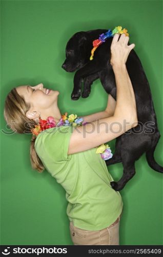 Caucasian prime adult female holding black puppy.