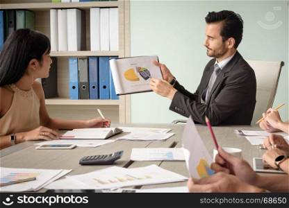 caucasian professional businessman present financial chart with team in the meeting, selective focus