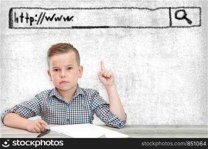 Caucasian school-age boy in a plaid shirt on a light background shows a window with the address of the site