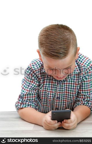 Caucasian school-age boy in plaid shirt on light isolated background playing games on phone. modern children, their interests