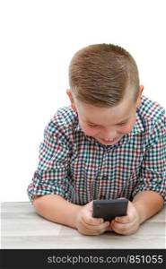 Caucasian school-age boy in plaid shirt on light isolated background playing games on phone. modern children, their interests