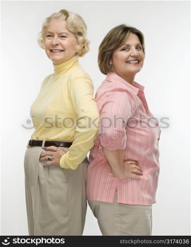 Caucasian senior woman and middle aged woman standing back to back.