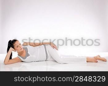Caucasian slim young woman lying on the floor after exercises