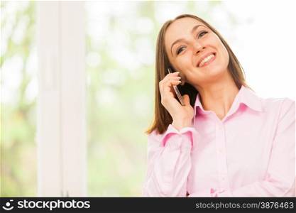 Caucasian smiling business woman is having a phone call