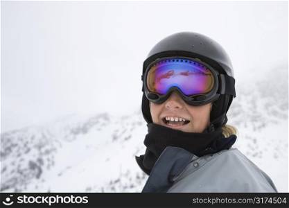Caucasian teenage boy skier in helmet and goggles at ski resort on mountain.