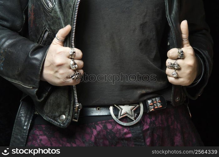 Caucasian woman&acute;s hands with silver rings holding onto black leather jacket.