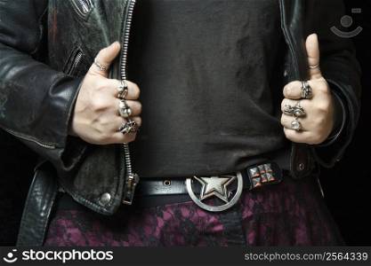 Caucasian woman&acute;s hands with silver rings holding onto black leather jacket.
