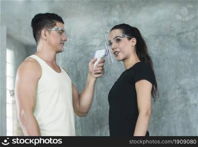 Caucasian woman doing fever measure before exercising in gym. Healthy and sport concept.
