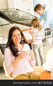 Caucasian woman drinking coffee in car retail store