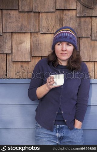 Caucasian Woman Drinking Coffee On A Cabin Porch