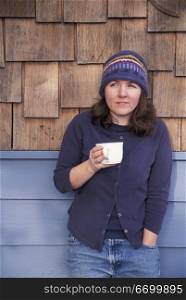 Caucasian Woman Drinking Coffee On A Cabin Porch
