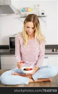Caucasian woman eating an appetizer with nuts, raspberries and blackberries. Concept of healthy diet.. Caucasian woman eating an appetizer with nuts, raspberries and blackberries.