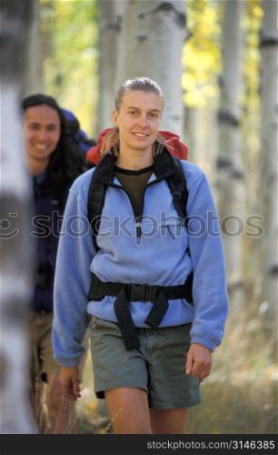 Caucasian Woman Hiking Through An Aspen Grove With Her Friend