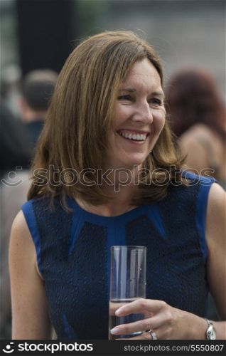 Caucasian woman holding a glass of water and smiling, Beijing, China