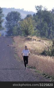 Caucasian Woman Jogging Along A Gravel Country Road
