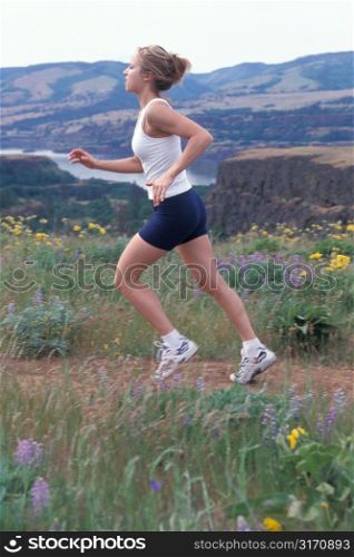 Caucasian Woman Jogging Along A Mountain Mesa