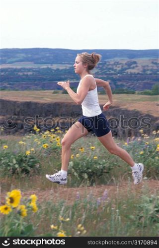 Caucasian Woman Jogging Along A Mountain Mesa