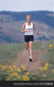 Caucasian Woman Jogging Through A Mountain Meadow
