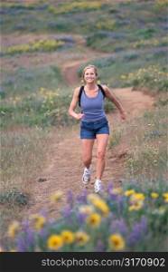 Caucasian Woman Jogging Through A Mountain Meadow