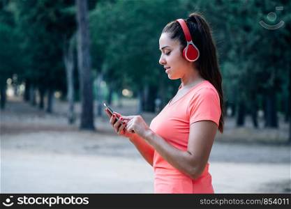 Caucasian woman listening to music while exercising in a park
