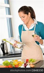 Caucasian woman preparing vegetables recipe cooking book meal kitchen