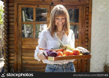 Caucasian woman smiling with a wooden tray stuffed with fruits