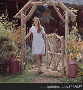 Caucasian Woman Standing At The Gate Of Her Mountain Cabin