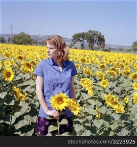 Caucasian Woman Standing In A Sunflower Field