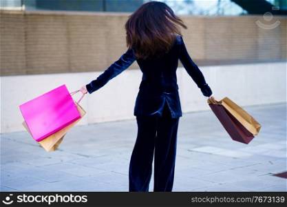 Caucasian woman turning with joy for her purchases in shopping bags. Lifestyle concept.. Caucasian woman turning with joy for her purchases in shopping bags.