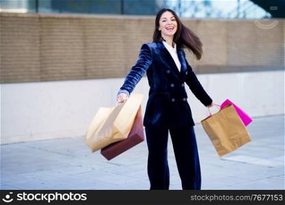 Caucasian woman turning with joy for her purchases in shopping bags. Lifestyle concept.. Caucasian woman turning with joy for her purchases in shopping bags.