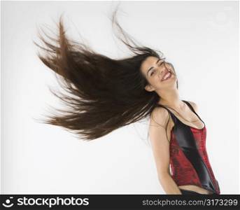Caucasian woman wearing corset swinging her hair.