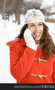 Caucasian young adult female on cell phone outdoors in the snow.