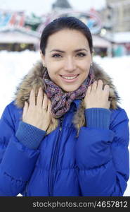 Caucasian young adult female smiling and walking down snow covered street