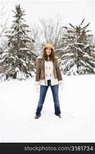 Caucasian young adult female standing in snow wearing straw cowboy hat.